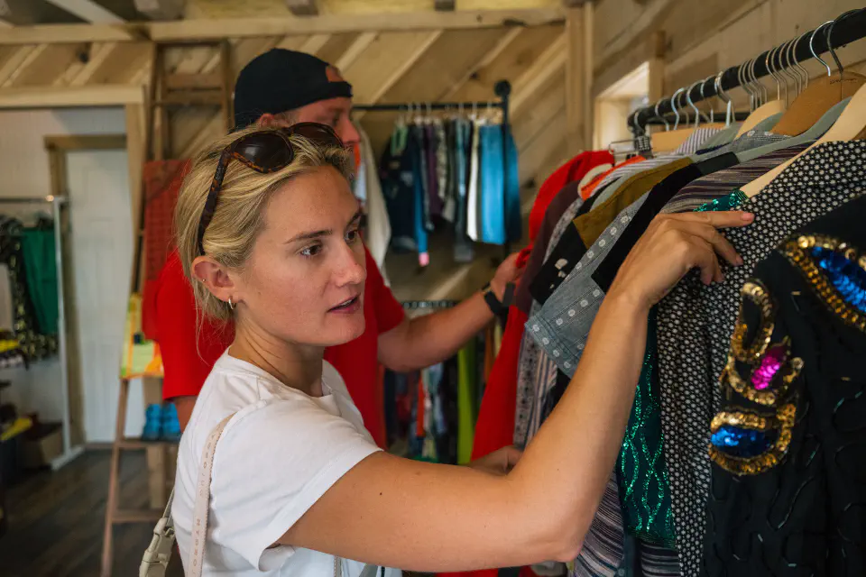 A women browsing clothing on a clothes rack in a store
