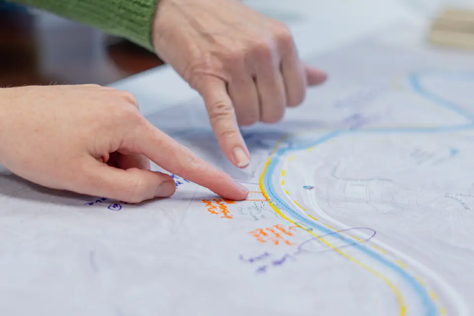 Two hands pointing at a spot on a map