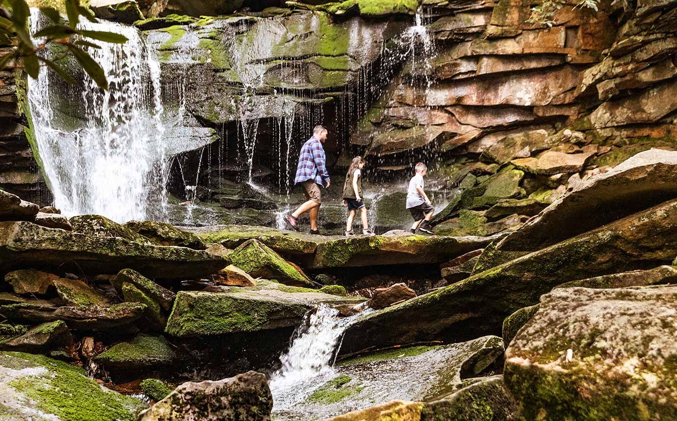 Family hiking near a waterfall.