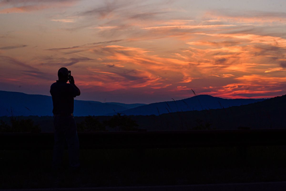 person taking a photo of a sunrise.