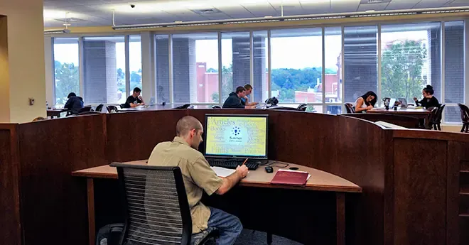 Students working at desks in the WVU downtown library.